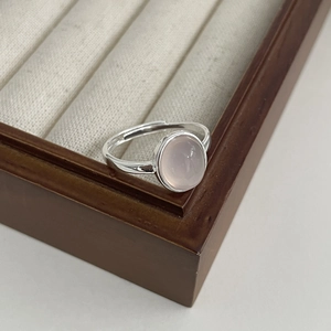 Bague élégante en argent 925 avec calcédoine rose ovale présentée sur un plateau bijoux