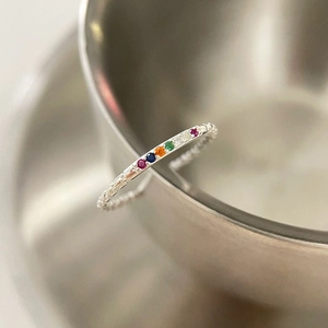 Macro shot of S925 silver ring featuring rainbow zircons and beaded texture band
