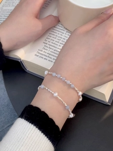 Macro shot of S925 silver pearl bracelet with blue aquamarine beads on a book