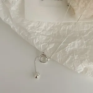 Detail of S925 sterling silver interlocking rings necklace with a sphere charm pendant