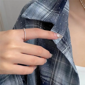 Close-up of minimalist silver ring with rainbow zircon stones on model's finger