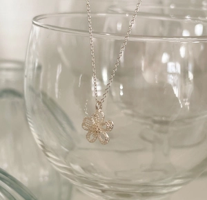 Close-up of S925 silver double-layer flower pendant with frosted texture and fine chain