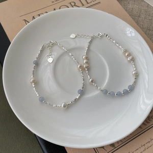 Detail view of S925 silver beaded bracelets with freshwater pearls and blue aquamarine stones