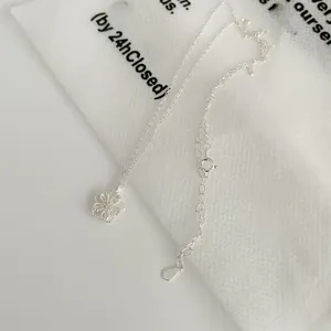 Macro shot of silver hollow flower pendant with woven texture and adjustable O-chain