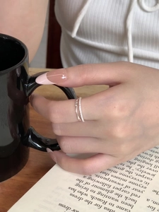Detail of double-layer S925 silver ring featuring micro-paved zircons and twisted rope design