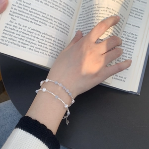 Detail of layered freshwater pearl and blue bead bracelet on a book background