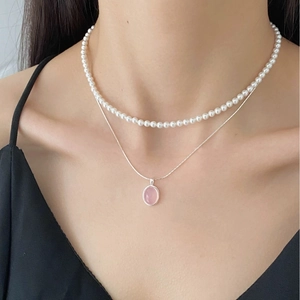 Close-up of layered S925 silver snake chain and pearl necklace with pink chalcedony