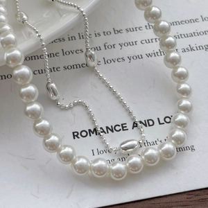 Macro shot of elegant S925 sterling silver chain with white pearls on a romantic background
