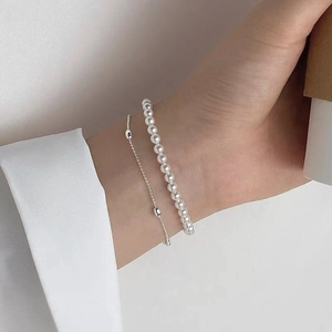 Close-up of double-layer S925 sterling silver bracelet featuring elegant round white pearls