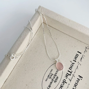 Detail view of the pink oval chalcedony pendant on a delicate S925 silver chain