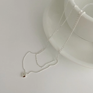 Detailed close-up of double-layered S925 sterling silver chain with a polished heart pendant