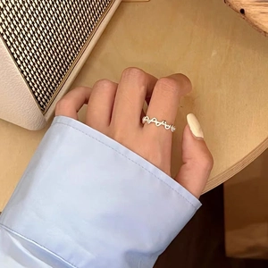 Dettaglio dell'anello intrecciato in argento al dito con il design minimalista S925