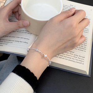 Detail of S925 silver beaded bracelet with natural pearls on a vintage book background