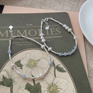 Close-up of S925 sterling silver heart charm with natural pearls and blue gemstone beads