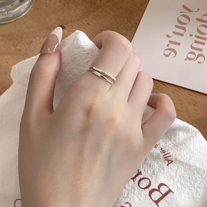 Macro detail of silver double-layered ring with sparkling pave cubic zirconia on finger