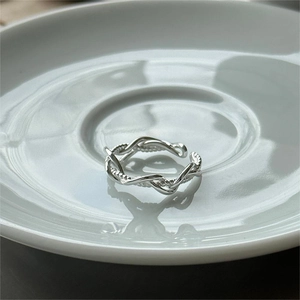 Detail of S925 sterling silver multi-layer twisted ring on a white ceramic tray