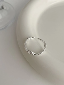 Detailed close-up of S925 sterling silver twisted multi-layer ring on a ceramic plate