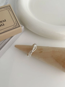 Close-up of S925 sterling silver multi-layer twisted ring on a wooden stand