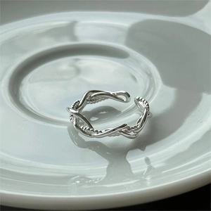 Close-up of S925 sterling silver multilayer twisted rope open ring on white ceramic