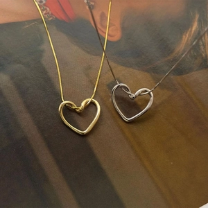 Detailansicht kleiner gedrehter Herz-Halsketten in Gold und Silber für Damen