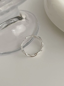 Macro shot of silver twisted multi-layer ring with intricate braided texture and adjustable band