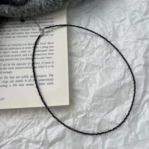 Fashionable black spinel beaded choker necklace with silver clasp on white background