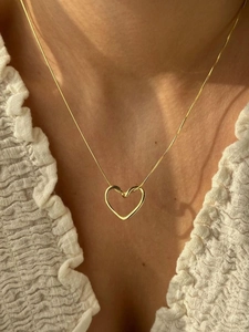 Nahaufnahme eines minimalistischen Herzanhängers aus Gold auf einer S925 Silberkette