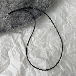 Detail of black faceted bead choker necklace with silver heart charm and lobster clasp