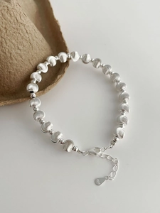 Detail of S925 sterling silver beads with brushed texture and lobster clasp on bracelet