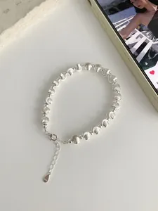 Detail of S925 sterling silver beaded bracelet with polished and brushed textures