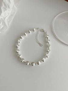 Macro shot of S925 sterling silver beaded bracelet with brushed texture and lobster clasp