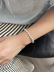 Polished silver beaded bracelet for women shown worn on wrist in a minimalist style