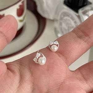 Elegant 999 silver bow earrings with sparkling cubic zirconia and round white pearls