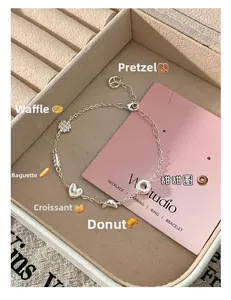 Vue macro d'un bracelet en argent S925 avec breloques de gaufres et de bretzels