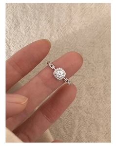 Detail of silver chain link ring with square cluster cubic zirconia on a finger