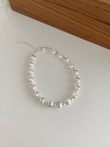 Macro shot of S925 sterling silver beaded bracelet with brushed texture and lobster clasp