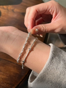 Detail of layered S925 sterling silver bracelets with snake chain and bamboo joint links