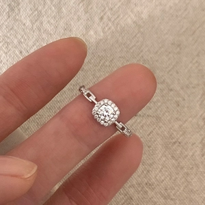 Silver chain style ring with square zircon and halo stones on female finger