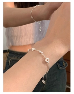 Gros plan détaillé du bracelet en argent sterling S925 avec pendentifs cœur sur un poignet