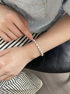 Close-up of minimalist S925 sterling silver beaded bracelet worn on a woman wrist