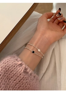 Gros plan de bracelets en argent S925 avec onyx noir et breloques en nacre blanche