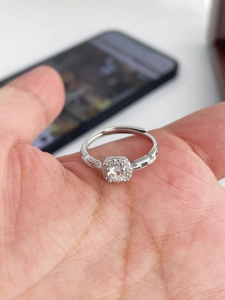 Close-up of a silver adjustable ring with a square-framed zircon in a hand