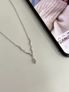 Macro detail of S925 sterling silver water drop pendant and wave shaped chain elements