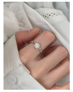 Detailed close-up of a square halo diamond ring with unique chain link band design