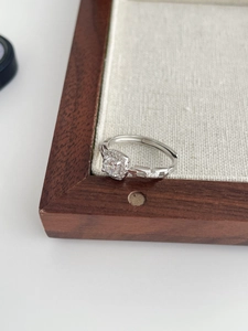 Macro shot of silver ring with round white zircon center and geometric chain band