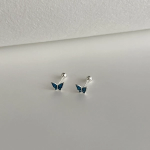 Close-up of blue butterfly 999 sterling silver stud earrings with screw back ball detail