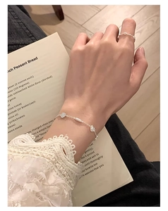 Détail du bracelet bretzel en argent sterling S925 avec breloques cœur sur main mannequin