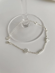 Détail d'un bracelet en argent sterling S925 avec breloques cœur et éléments géométriques