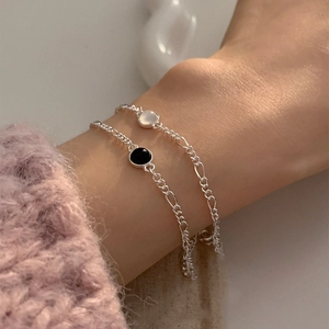 Bracelets élégants en argent S925 avec onyx noir et pierre blanche au poignet féminin
