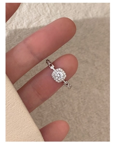 Macro shot of square cut halo ring with a unique chain-link style band on a finger